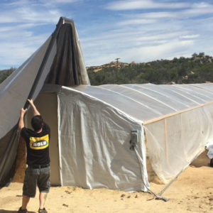Bold light deprivation greenhouse with tarp puller