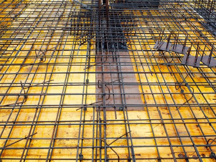 A construction site shows a yellow vapor barrier installed for use under concrete slabs.